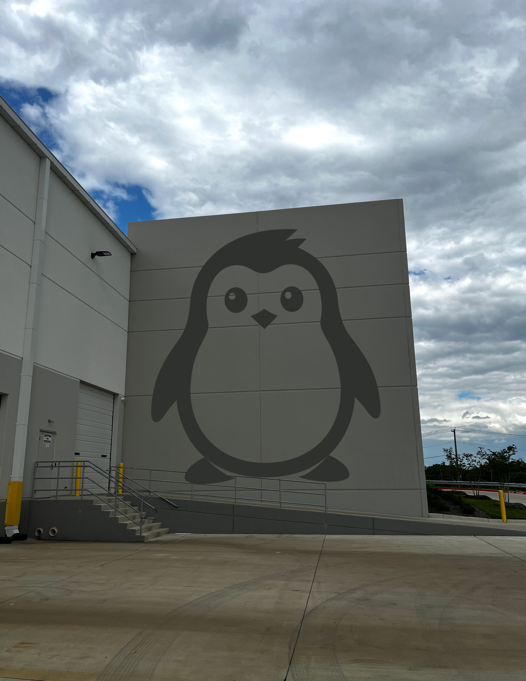 Large Penguin mascot painted on the warehouse exterior