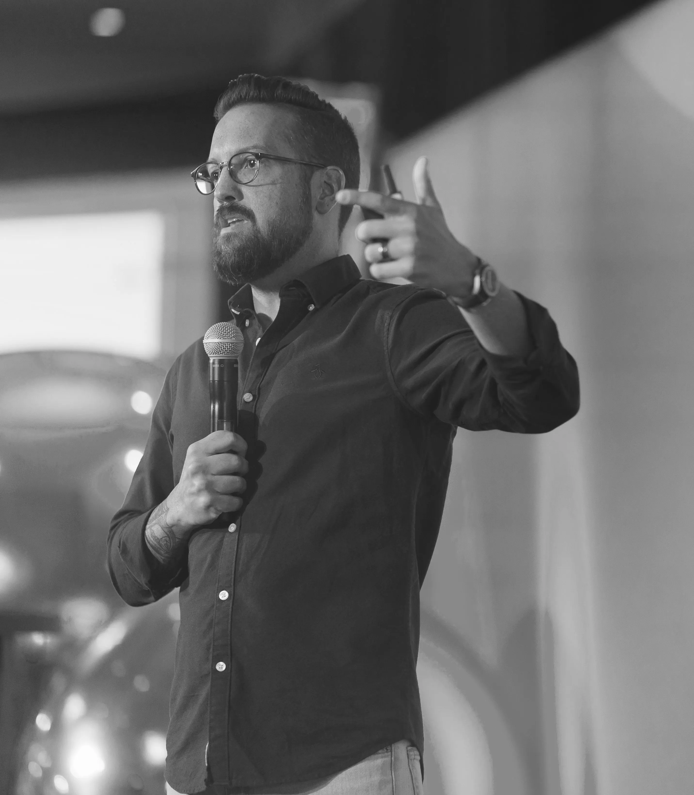 Jason VanLue speaking on stage, microphone in hand